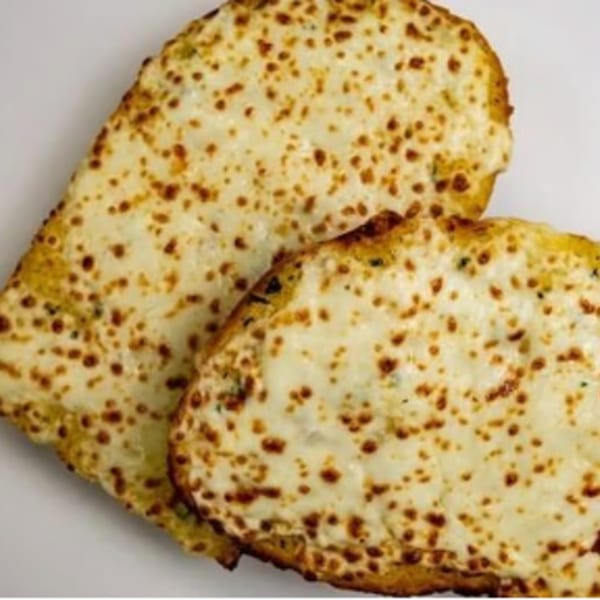 Two slices of cheesy garlic bread, golden brown and covered in melted mozzarella, on a white surface.